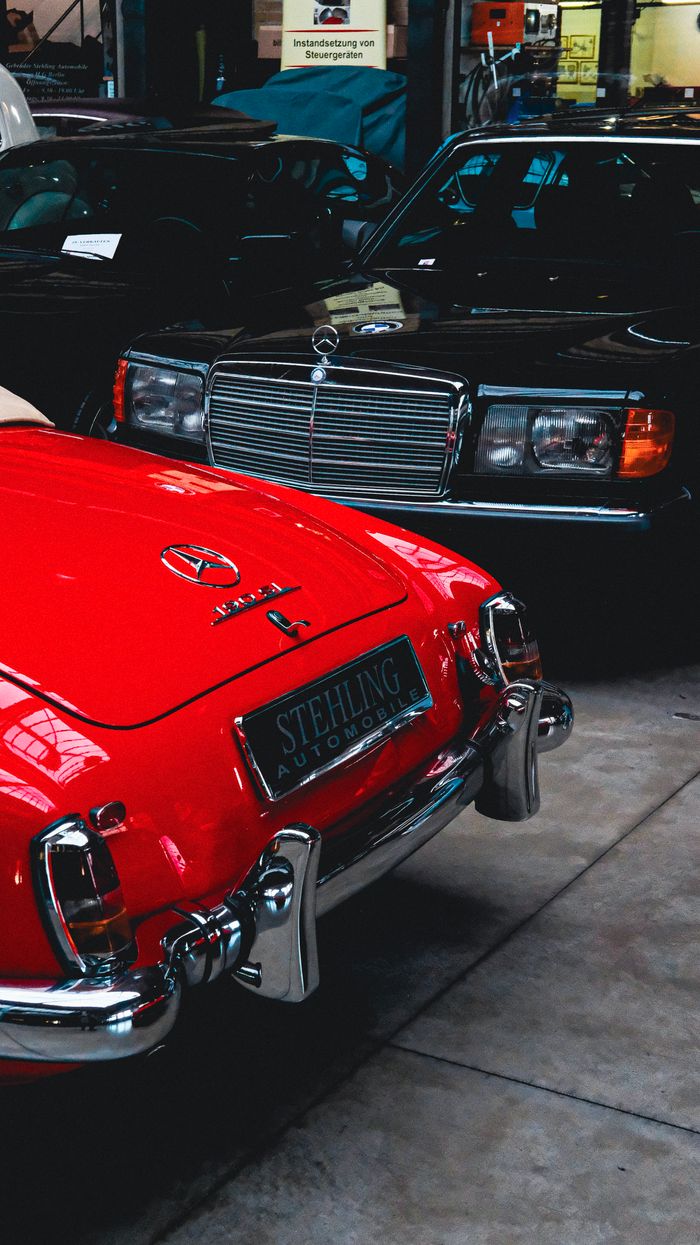 A indoor display of vintage and classic Mercedes Benz cars in a showroom setting.