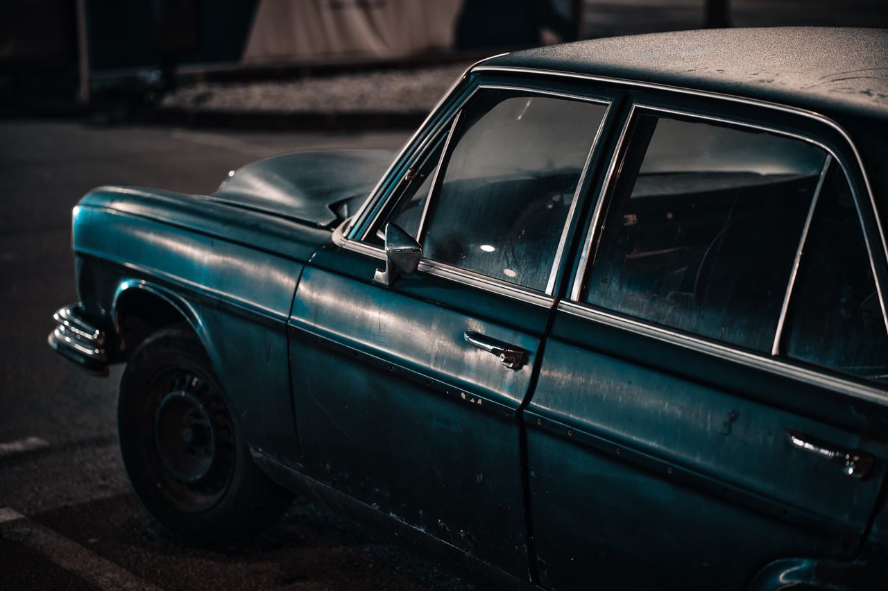 Close-up of a classic car parked at night, showcasing vintage style and urban mood.