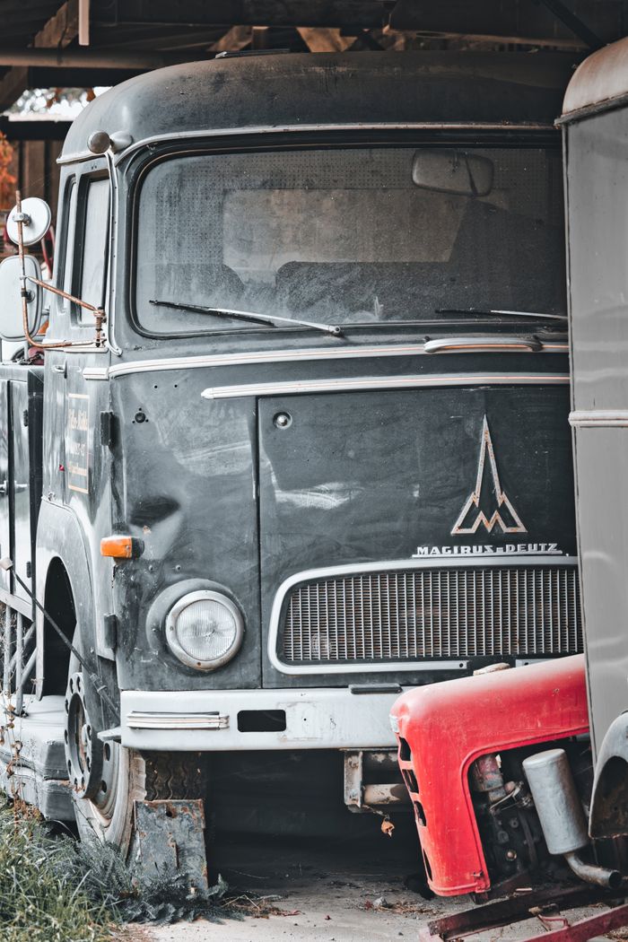 Retro Magirus Deutz truck parked in a rustic industrial environment, showcasing vintage transportation charm.